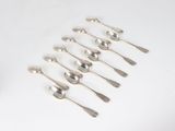 six silver spoons and two silver spoons on a white surface