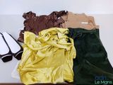 un tas de vêtements posés sur une table, avec une paire de chaussures