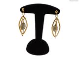 gros plan d'une paire de boucles d'oreilles sur un support