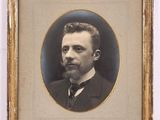 portrait of a man in a suit and tie in a gold frame