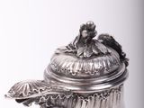 a silver tea pot with a lid on a table