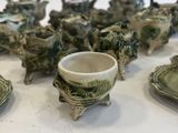 many pieces of pottery sitting on a white table