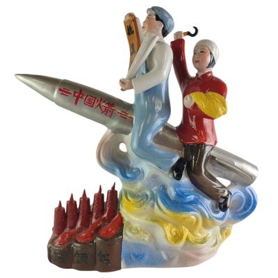a figurine of a man and a woman on a surfboard