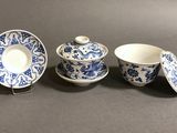 three pieces of blue and white porcelain dishes and cups on a table