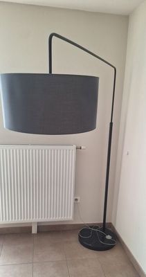 a lamp that is on the floor next to a radiator
