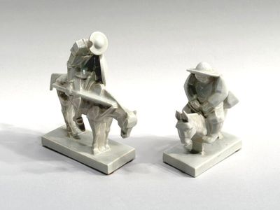 two figurines of a man and a woman sitting on a bench