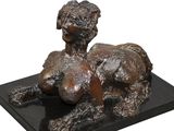 statue of a dog laying down on a black marble base