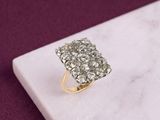 an image of a diamond cluster ring on a marble surface