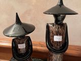 deux vases posés sur une table, surmontés d'un chapeau noir