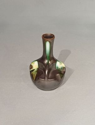 un petit vase orné d'un motif vert et jaune
