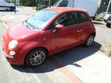 a small red car that is parked on the side of the street