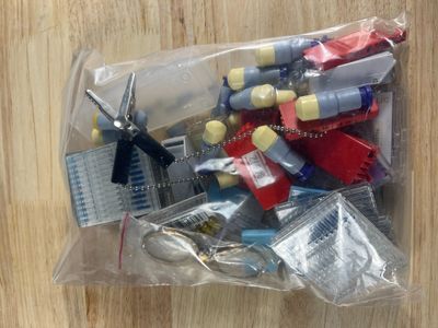 un sac en plastique rempli d'objets divers posé sur une table en bois