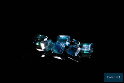 some very pretty blue crystals on a black surface