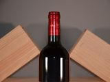 a bottle of red wine sitting on a wooden table