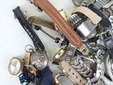 a pile of assorted watches and watches on a white surface