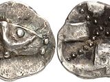 une pièce d'argent avec un œil au recto et un visage au verso