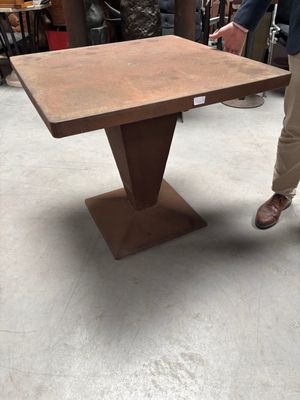 L'homme se tient à côté de la table dans le magasin.