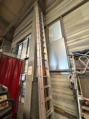 a ladder that is next to a window in a building
