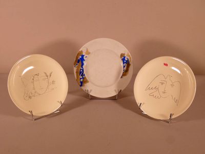 three plates with drawings on them are sitting on a table