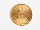 a close up of a gold coin on a white surface