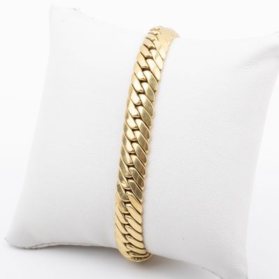 a gold bracelet on a white pillow on a white pillow