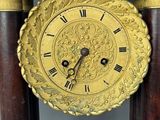 a clock that is sitting on a stand in the room