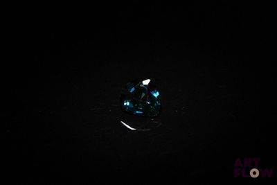 gros plan d'un diamant bleu sur une surface noire