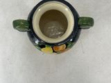 a small vase with a turtle on it sitting on a table
