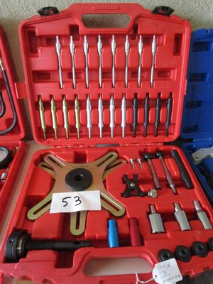 une mallette rouge contenant des outils, posée par terre