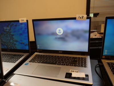 three laptops are sitting on a table with a remote in front of them