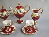 four pieces of red and gold tea set on a table