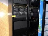 un réfrigérateur dont les étagères, dans la pièce, sont garnies de verres à vin
