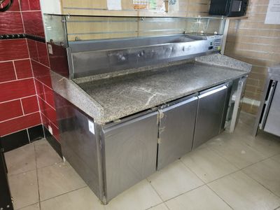 stainless steel counter top in a commercial kitchen with a red tiled wall