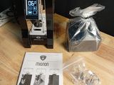 a coffee machine sitting on a table next to a package of items