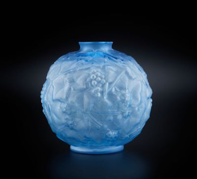 un vase en verre bleu posé sur une surface noire