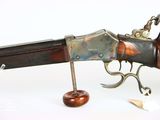 a close up of a gun with a wooden handle on a white surface