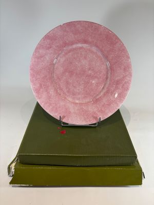 a pink plate sitting on top of a stack of books