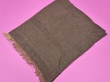une écharpe marron à franges sur fond rose