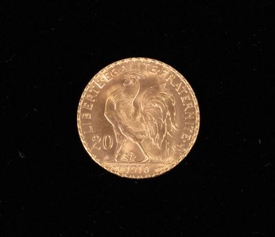 a close up of a gold coin on a black surface