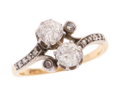 un gros plan d'une bague en diamant et en or sur fond blanc