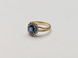 a close up of a gold ring with a blue stone