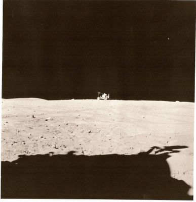photographie en noir et blanc d'un astronaute sur la Lune, avec une navette spatiale en arrière-plan