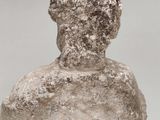 a close up of a stone statue of a man with a hat on