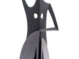 a metal sculpture of a woman sitting on top of a chair