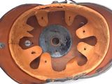 a close up view of a rusted orange wheel on a white surface