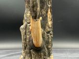 a close up of a statue of an elephant holding a piece of wood
