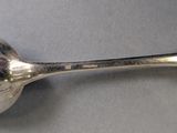 a silver spoon with a spoon handle on a table