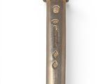 a silver spoon with a gold handle on a white surface