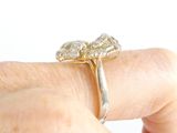 a woman ' s hand holding a gold ring with three diamonds