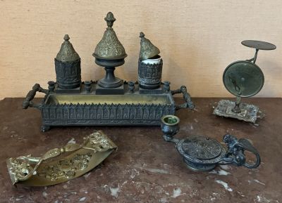 a table topped with a clock and other antique items